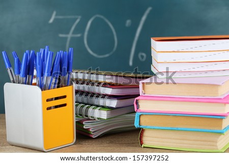 Office supplies on table on school board background 