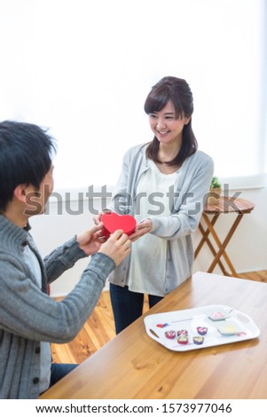 Wife giving chocolate to her husband