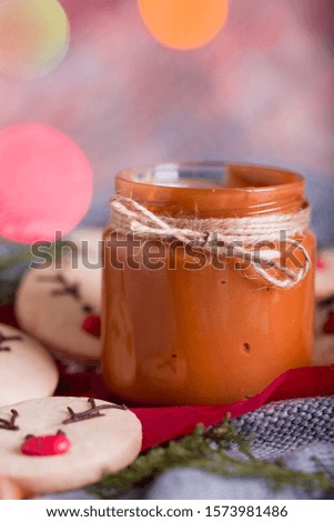 Christmas cookies with homemade salted caramel on a wooden background, neon lights, cinnamon sticks. New years 2020