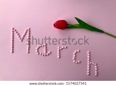 text march written in beads on delicate pink color