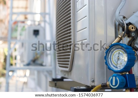 Technicians use manifold gauges to check the refrigerant pressure of air conditioners.