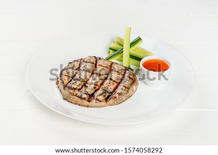 Grilled cutlet on a white plate shot isolated on a white background