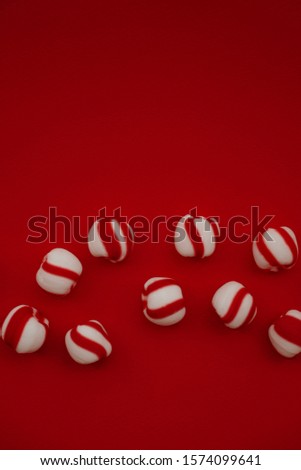 Peppermint candies on vivid red background from above. Winter, New Year, Christmas seasonal minimalism still life, flat lay. Copyspace for text. 