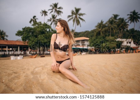 Happy woman in swimwear on the beach in Sri Lanka. 