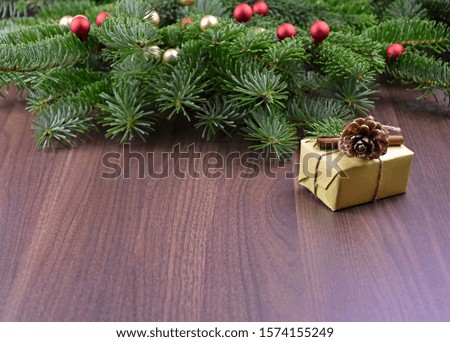 Christmas gift on a wooden background stock images. Beautiful natural Christmas background. Christmas decorations on a wooden background. Xmas tree branch with gift box. Natural christmas images