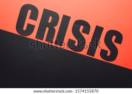 top view of word crisis on black and red background divided by sloping line 