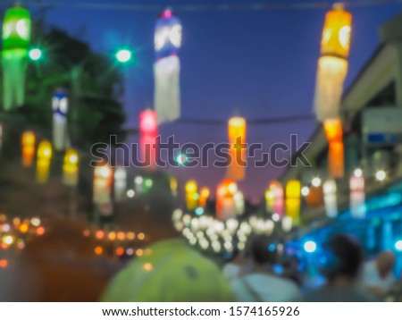 Abstract blurry people movement, multicolored colorful bokeh, traditional paper lamp. Festival in the park, night lights, art, creativity, glittering pattern, texture and background concept and idea.