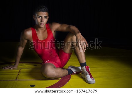 Young wrestler sitting on the ring