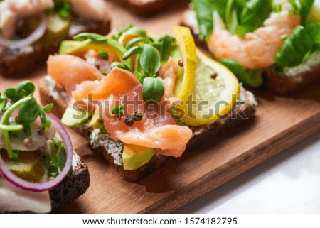 selective focus of salmon fillet near sliced lemon on tasty smorrebrod sandwich 