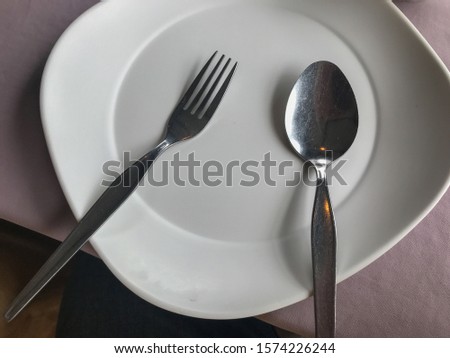 close up of empty white plate fork and spoon