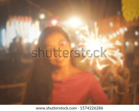 Blur Picture A beautiful woman looking at a firecracker holding her hand.
