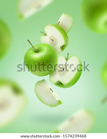 Flying green apple slices on color background. Green apple photo art for poster, banner