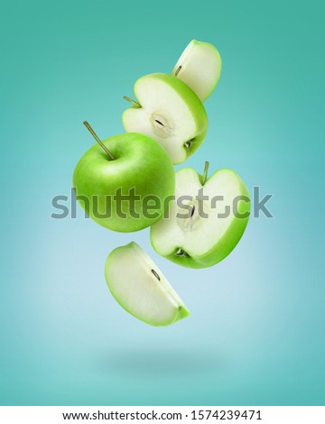 Flying green apple slices on color background. Green apple photo art for poster, banner