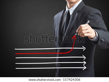 Businessman drawing arrows in different directions