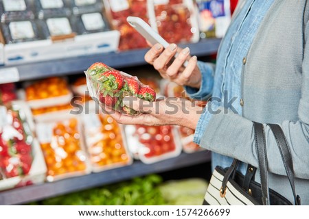 Customer scans pack of strawberries with the smartphone app for product comparison
