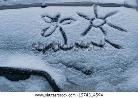 drawing on the windshield of the car, winter weather.