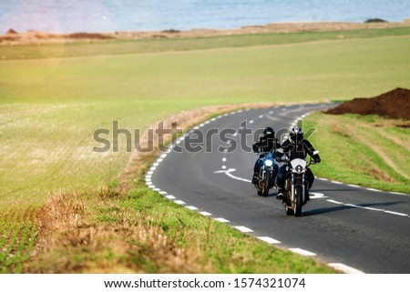 couple riding a motorcycle along the coast