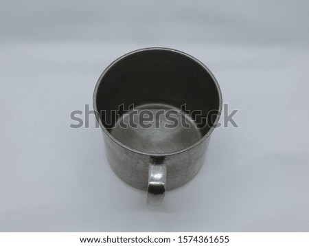 a medium sized metal cup for hot or cold drink shot from top with water stains isolated on white background 