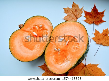 sliced pumpkin and autumn leaves on a white background