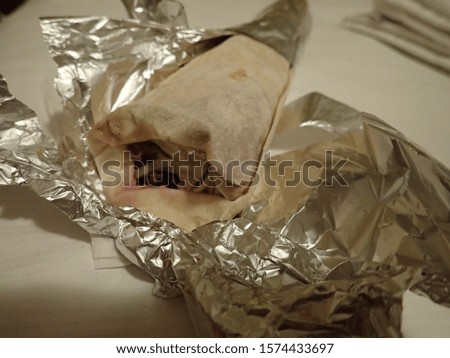 fresh takeaway meat and salad tortilla packed in paper