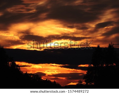 dying sunset flame on a dark gray background of clouds