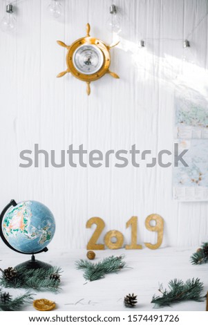 Globe on white wooden background with barometer.