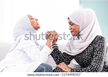 African woman  arm wrestling conflict concept, disagreement and confrontation wearing traditional islamic hijab clothes
