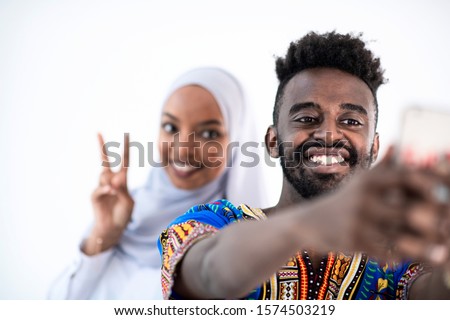 young african muslim business couple making selfie photo with smartphone isolated on white background in studio happy students group taking self portrait
