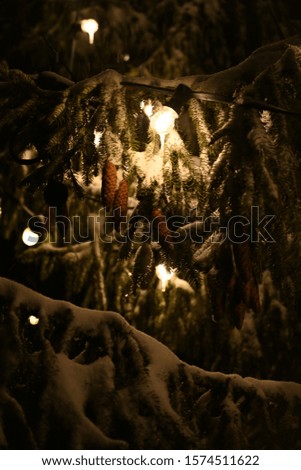 Snowy Christmas tree with cones and lights