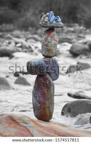 Stack of stones on the banks of the turbulent Verzasca River in Europe Alps - meditation and calm land art of people travelers in Switzerland