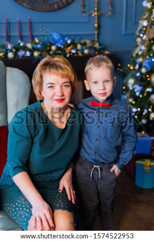 Happy grandmother with grandson cuddling new year.
