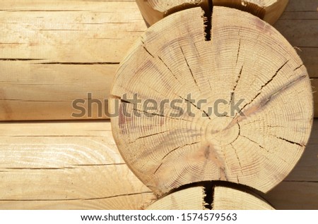 Part of a wooden log cabin for a sauna close-up front view brown background.