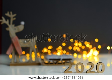 Christmas and New Year Decorate on grey background,wooden numbers 2020 with bokeh New Year's lights. deer rudolph,The concept of the New Year, New Year's Eve, winter holidays. copy space, soft focus
