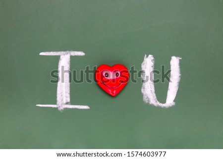 the inscription I love you on a green chalk board, a red heart with a smile. valentine's day concept