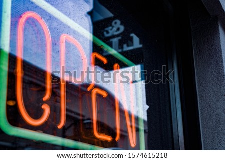 Neon open sign with reflective glare. 