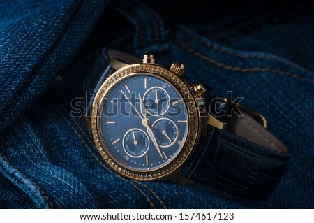 golden wristwatch with stones lie on the fabric Royalty-Free Stock Photo #1574617123