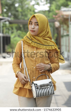 Asian Muslim women wear golden yellow hijab in city parks