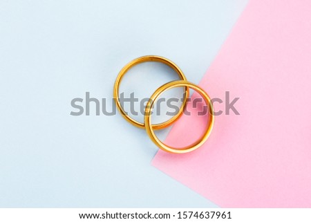 two golden rings,on a pink on blue 
 table
