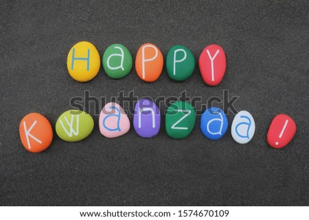 Happy Kwanzaa, cultural celebration with colored stone letters over black sand