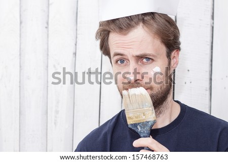 Close up portrait of caucasian forty years old man with a brush. Renovation - painting walls