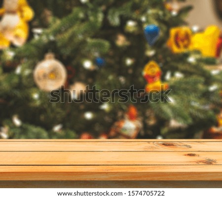 Wood table over Christmas tree with decoration blur background. can be used for display or montage products.