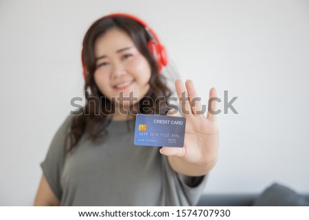 Overweight female (Plus size Asian model , Big woman , fat person) smiling Happy Positive thinking lifestyle concept. Living room background. Shopping Online with Credit card concept. Showing gesture