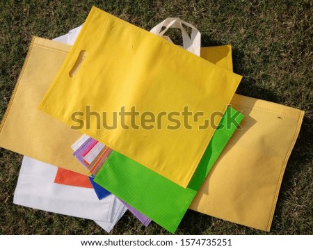 yellow Colored Poly Non Woven Bags on Green grass Background 