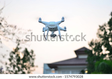 drone flying front of home and trees blurred background orange sky morning.