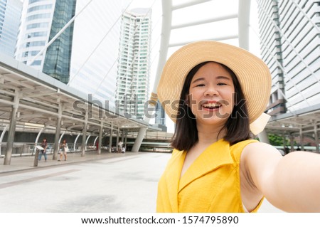 Beautiful Asian woman in yellow dress selfie her picture for use as a online profile picture.
