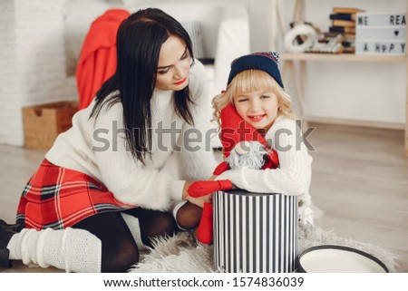 Beautiful mother in a white sweater. Family sitting near presents