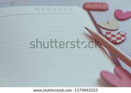Blank or plain notebook, sharp pencil and lovely hearts with copy space. Conceptual realtionship of romance couple or lover, family, friends, happiness together. Love photo frame and valentine concept