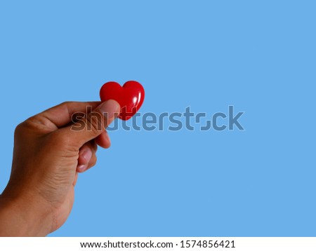 Gift red heart hold in hand. Royalty high-quality free stock images of hands holding gift red heart, health care, valentine, love and family concept, world heart day isolated on green background