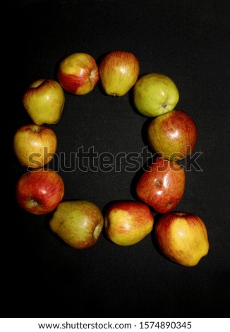 Colorful fresh apples letter alphabet photographed against a black background. - Image