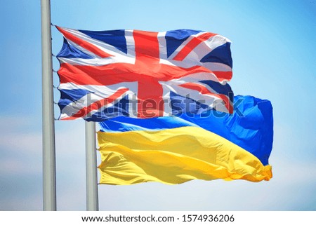 British and Ukrainian flags against the background of blue sky